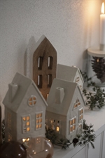 Hus til fyrfadslys Stillenat med buet vinduer fra Ib Laursen med lys på reol - Tinashjem